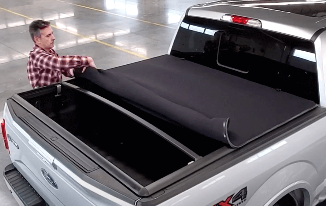 Rolling up Sawtooth Stretch expandable tonneau cover on a 2020 Ram 1500 5' 7" Bed